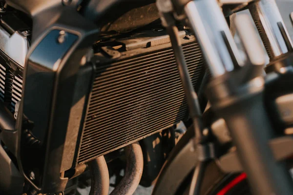 在阳光下对一辆黑色摩托车机械细节的选择性聚焦拍摄 — 图库照片