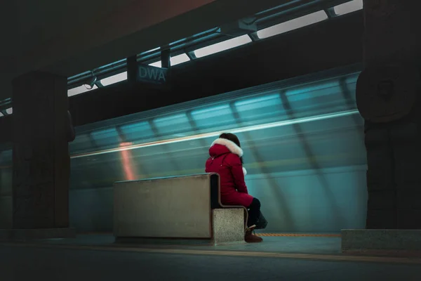 여자가 초점을 맞추고 벤치에 모습이 희미하게 비치는 지하철역 — 스톡 사진