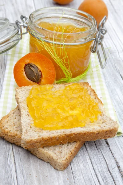 Disparo Vertical Frasco Mermelada Albaricoque Fresco Poco Pan Una Mesa — Foto de Stock