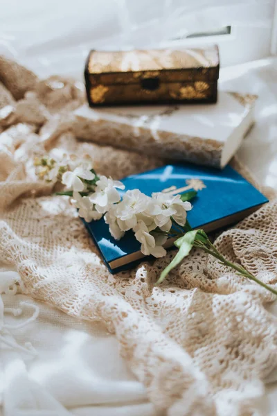 Pionowe Ujęcie Niebiesko Białych Zeszytów Pudełko Biżuterią Sztuczny Kwiat Nagim — Zdjęcie stockowe