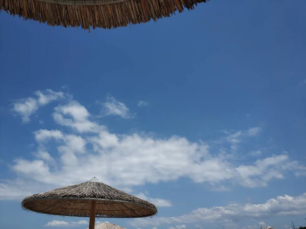 Colpo Basso Angolo Ombrelloni Paglia Sulla Spiaggia Durante Giorno — Foto Stock