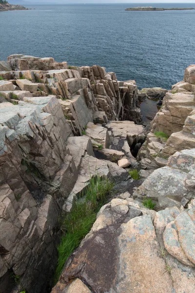 白天被大海包围的岩石和悬崖峭壁的垂直镜头 — 图库照片