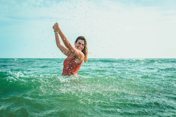 오렌지색 수영복을 아름다운 여자가 바다에서 재미있게 — 스톡 사진