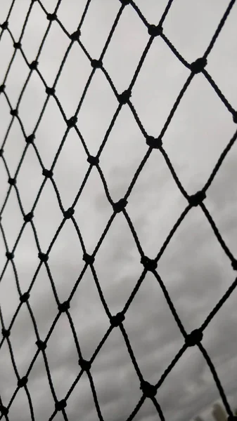 灰色の曇り空の背景に黒いネットのクローズアップショット — ストック写真