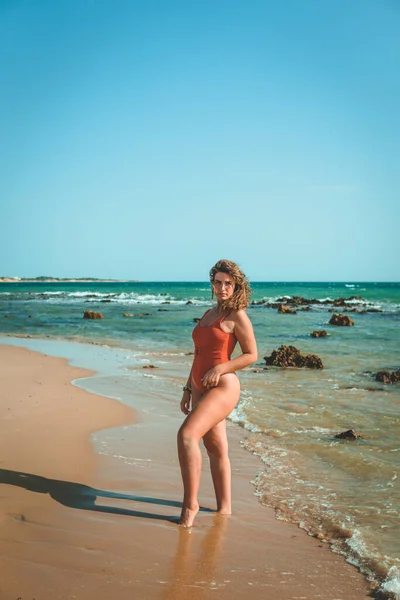 Вертикальный Снимок Красивой Европейской Женщины Оранжевом Купальнике Позирующей Пляже — стоковое фото
