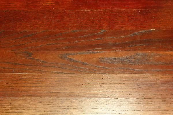 照明の下に傷を持つ木製のラミネート床のトップビュー — ストック写真