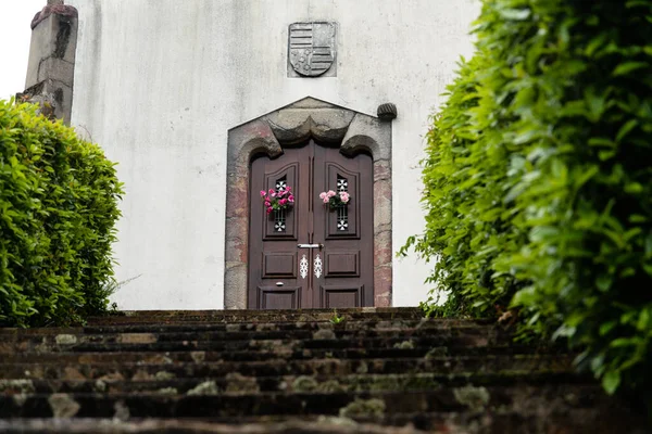 Tiro Ángulo Bajo Una Puerta Edificio Rodeada Arbustos Verdes —  Fotos de Stock