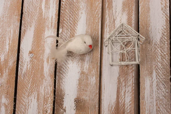 Tahta Arka Plandaki Yuvanın Yanında Yapay Bir Kuş — Stok fotoğraf