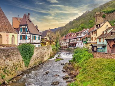 A beautiful shot of buildings and a river in Kaysersberg, France clipart