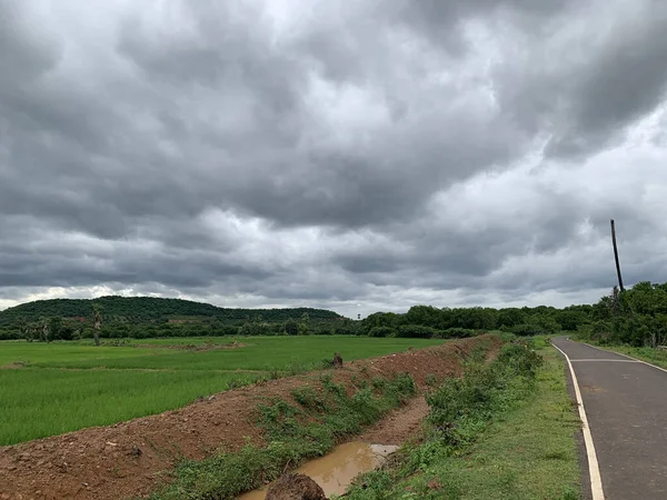 一片绿地的美丽风景 被乌云密布的群山环绕着 — 图库照片