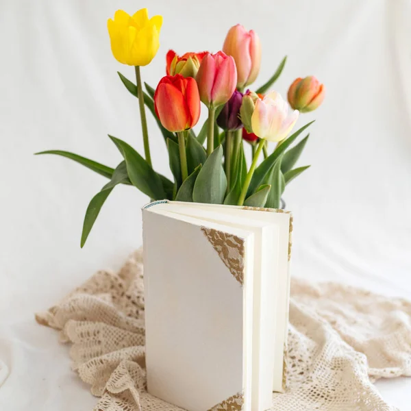 Selektywne Ujęcie Białej Książki Kolorowymi Tulipanami Białym Tle — Zdjęcie stockowe