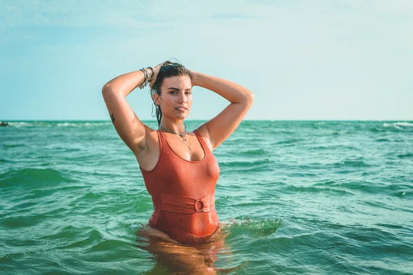 一个漂亮的欧洲女人穿着橙色泳衣在海上玩得很开心 — 图库照片