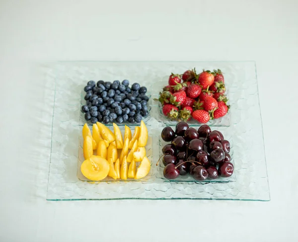 アプリコット イチゴ チェリー ブルーベリーと正方形のフルーツプレートの高い角度のショット — ストック写真