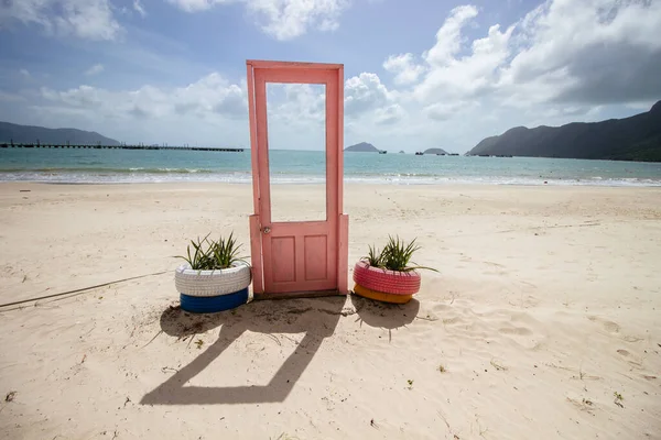 ベトナムのコンダオの海岸で両側にタイヤの植物とピンクのドアの眺め — ストック写真