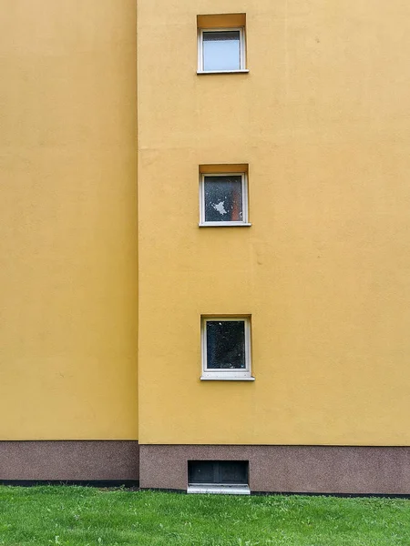 Eine Vertikale Aufnahme Einer Gelben Wand Mit Kleinen Fenstern — Stockfoto