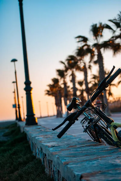 一辆停在街上的自行车的垂直镜头 背景是日落 — 图库照片