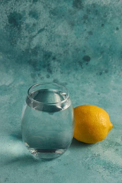 Una Toma Vertical Vaso Agua Limón Sobre Fondo Azul — Foto de Stock