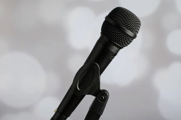 Person Holding Black Microphone Grey Background White Bokeh Lights — Stock Photo, Image