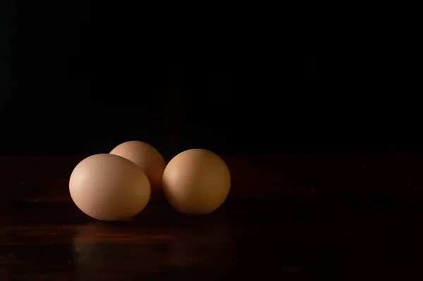 Trois Œufs Poulet Isolés Sur Fond Sombre — Photo