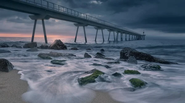 Дивовижний Знімок Піщаного Кам Янистого Пляжу Сучасним Пірсом Фоні Заходу — стокове фото