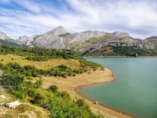 スペインのリアノの背後にある美しい山岳風景の砂の海岸線の素晴らしいショット — ストック写真