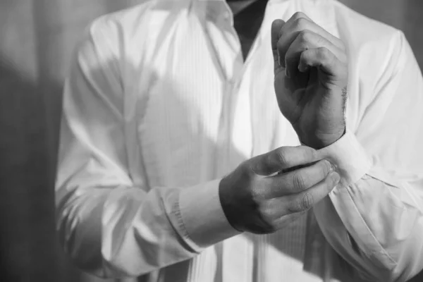 一个男人把纽扣系在一件经典的衬衫上 — 图库照片