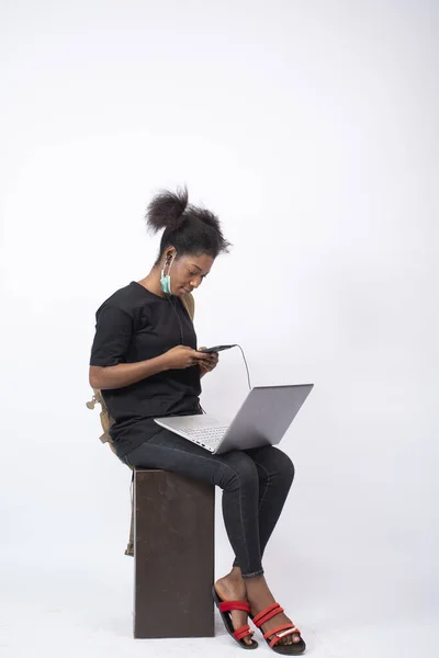 Африканская Женщина Сидит Одна Белом Фоне Использует Свой Мобильный Телефон — стоковое фото