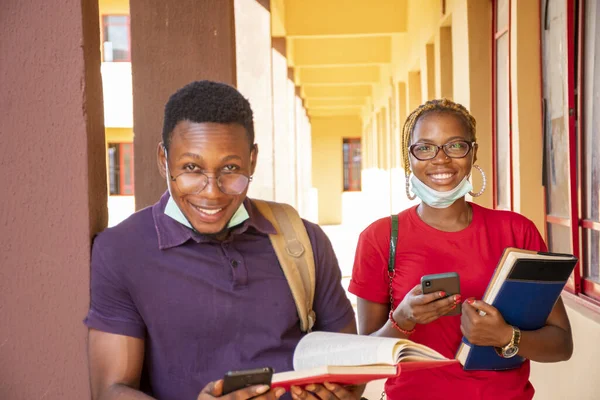 Due Giovani Studenti Africani Indossano Maschere Tengono Libri Telefoni Campus — Foto Stock