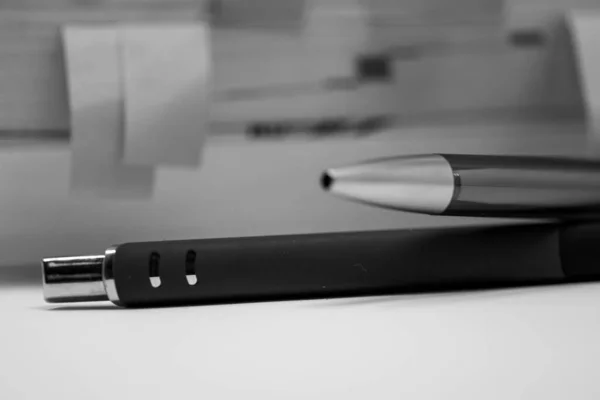 Eine Graustufenaufnahme Von Zwei Kugelschreibern Auf Einer Weißen Oberfläche — Stockfoto