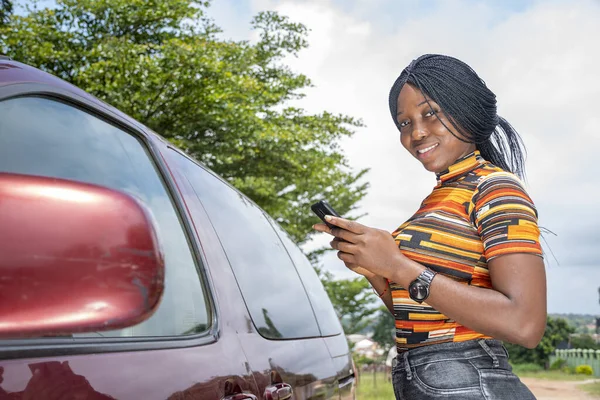 Uma Jovem Negra Perto Carro Sorrindo Usando Seu Telefone Celular — Fotografia de Stock