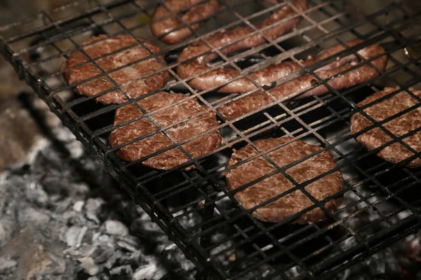 火で焼かれる牛肉とソーセージ — ストック写真
