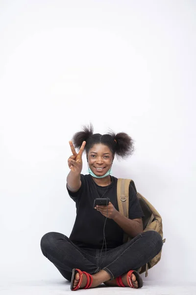 Довольно Африканская Женщина Рюкзаком Скрещенными Ногами Используя Свой Мобильный Телефон — стоковое фото