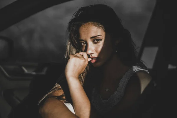 Zbliżenie Młodą Kobietę Ciemnymi Włosami Pozującą Samochodzie — Zdjęcie stockowe