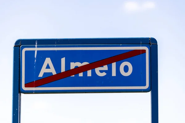 ALMELO, NETHERLANDS - Aug 06, 2020: Traffic sign denoting that you are about to enter a residential area in which speed limits are in place with fluffy clouds in clear sky behind — Stock Image Almelo Netherlands Aug 2020 Traffic Sign Denoting You Enter Residential Stock Photo