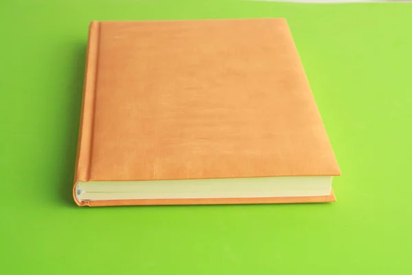 Cuaderno Con Una Cubierta Naranja Sobre Una Superficie Verde —  Fotos de Stock