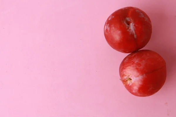 Dos Deliciosas Ciruelas Frescas Sobre Una Superficie Rosada — Foto de Stock