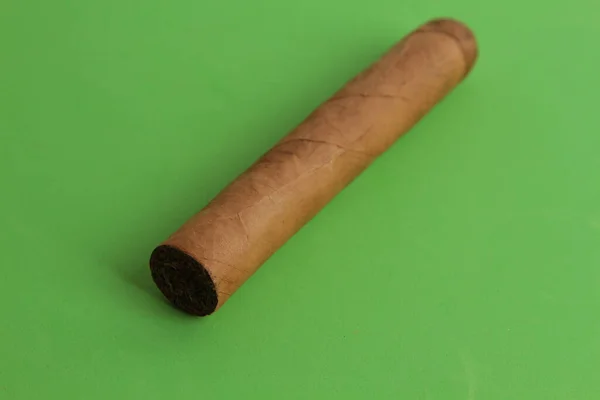 Een Closeup Van Een Tabak Sigaar Een Groen Vlak Onder — Stockfoto
