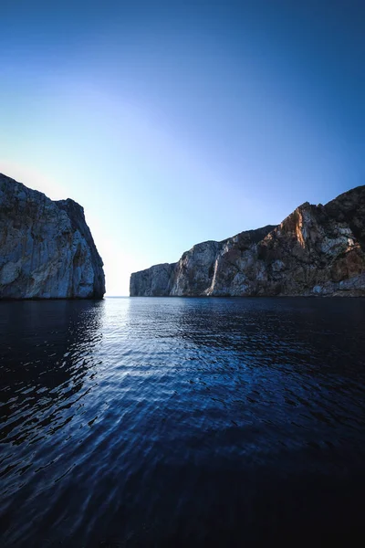 Вертикальный Снимок Моря Скалами Заднем Плане — стоковое фото