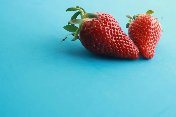 Zwei Erdbeeren Auf Blauer Oberfläche — Stockfoto