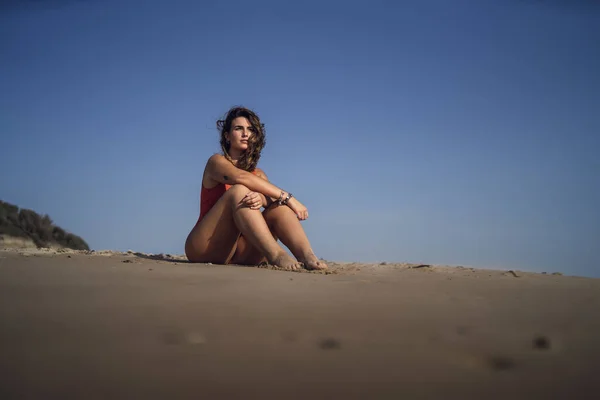 一位漂亮的女性坐在西班牙罗塔海滩上 在刮风的日子里穿着泳衣 — 图库照片