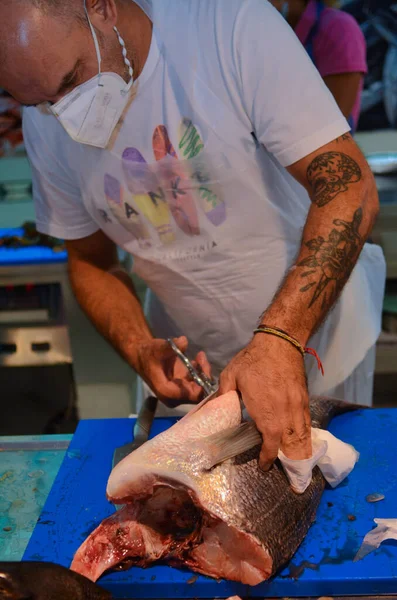 Spezia イタリア 2020年8月8日 入れ墨と顔のマスク洗浄と市場での生の魚の準備を持つ肉屋 — ストック写真