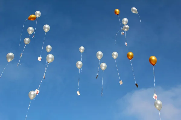 青い空に白い気球と黄金の気球を飛んでの低角度ショット — ストック写真