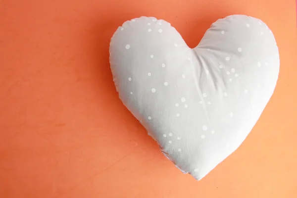 Ein Weiches Herzförmiges Kissen Auf Orangefarbener Oberfläche — Stockfoto