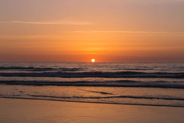 Een Majestueuze Oranje Zonsondergang Boven Een Golvende Rustige Zee — Stockfoto