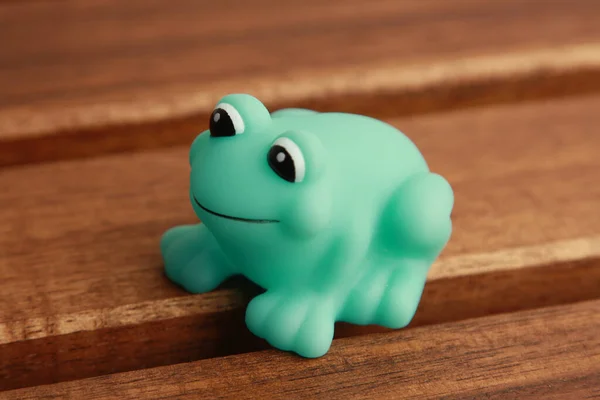 A close up shot of a toy green frog for a bathtub