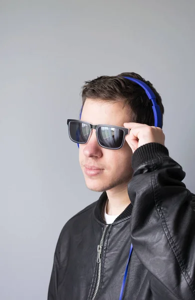 一个戴着太阳镜和耳机听音乐的时髦的现代青少年 — 图库照片