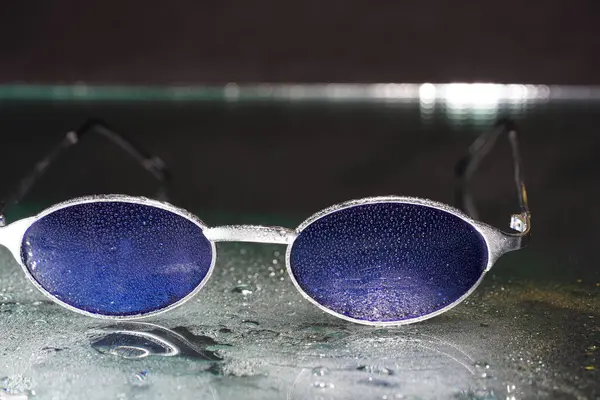Eine Nahaufnahme Moderner Sonnenbrillen Mit Wassertropfen Darauf Unter Den Lichtern — Stockfoto