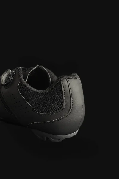 Eine Vertikale Aufnahme Eines Schwarzen Mtb Schuhs Auf Schwarzem Hintergrund — Stockfoto
