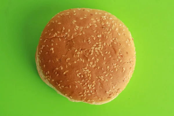 Yeşil Zemin Üzerinde Susam Tohumları Olan Bir Hamburgerin Üst Görüntüsü — Stok fotoğraf