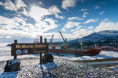 NONE, UNITED STATES - Jan 02, 2019: Mcmurdo Station Antarctica sign with cargo ship unloading clipart